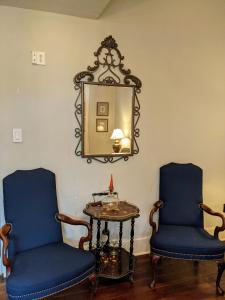 two blue chairs and a table with a mirror at Balcony Guest House in New Orleans