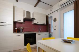 トリノにあるSanta Chiaraのキッチン(白いキャビネット、テーブル、黄色い椅子付)