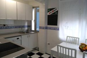 a kitchen with white cabinets and a table with a bowl of fruit at Alojaguay RONDILLA in Valladolid