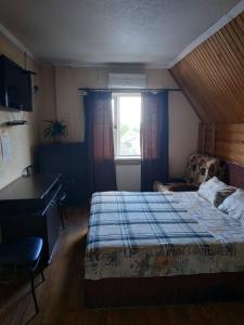 a bedroom with a bed and a desk and a window at Hotel Restaurant Complex Boyarskiy Dvor in Boyarka