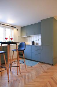 kuchnia z niebieskimi szafkami oraz stołem i krzesłami w obiekcie Saga Caves Straen w Stavangerze