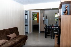 a living room and kitchen with a couch and a table at Hospedagem D´Roos in Canela