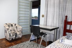 um quarto com uma secretária, uma cadeira e uma cama em Ecohouse - Próx da Av Brasil em Franca