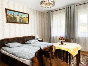 1 dormitorio con 1 cama, 1 mesa y 1 pintura en Bauernhaus Moser, en Nötsch