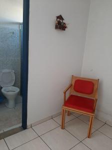 uma cadeira vermelha numa casa de banho com WC em Estância Morro Do Frota em Pirenópolis