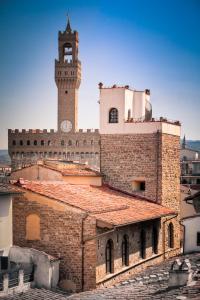 ein Gebäude mit einem Uhrturm darüber in der Unterkunft Hotel Torre Guelfa Palazzo Acciaiuoli in Florenz
