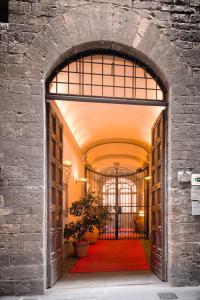 un accès à un bâtiment doté d'un tapis rouge dans l'établissement Hotel Torre Guelfa Palazzo Acciaiuoli, à Florence