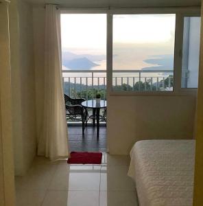 a bedroom with a view of a balcony with a table at Bella Suites at Wind Residences Tagaytay in Tagaytay