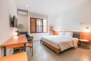 1 dormitorio con cama, mesa y escritorio en Djajanti House en Semarang