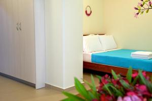 a small bedroom with a bed with blue sheets and flowers at Ilida Kourouta Studios in Kourouta