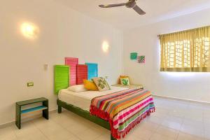a bedroom with a bed, a desk, and a lamp at Vainilla Bed and Breakfast Mexico in Playa del Carmen
