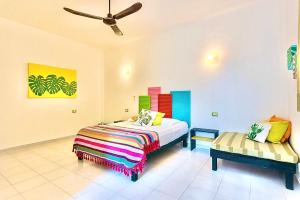 1 dormitorio con cama y banco. en Vainilla Bed and Breakfast Mexico, en Playa del Carmen