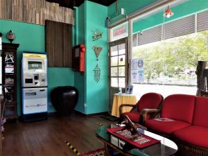 a living room with a red couch and a gas station at Blue Eyes Hotel in Kepala Batas