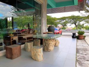 a table and stools in front of a store at Blue Eyes Hotel in Kepala Batas