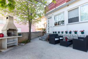 une terrasse avec 2 chaises et une cheminée dans une maison dans l'établissement Apartment Rene, à Krk