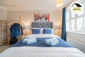 a bedroom with a large bed with blue pillows at Javelin House- B and R Serviced Accommodation Amesbury, 3 Bed Detached House with Free Parking, Super Fast Wi-Fi and 4K Smart TV in Amesbury