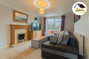 a living room with a couch and a fireplace at Javelin House- B and R Serviced Accommodation Amesbury, 3 Bed Detached House with Free Parking, Super Fast Wi-Fi and 4K Smart TV in Amesbury