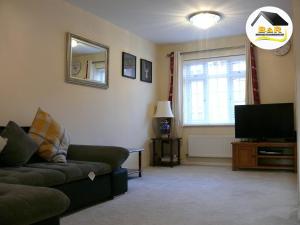 a living room with a couch and a television at B and R Serviced Accommodation, 3 Bedroom House with Free Parking, Super fast Wi-Fi 145Mbps and 4K smart TV, Barnard House in Amesbury