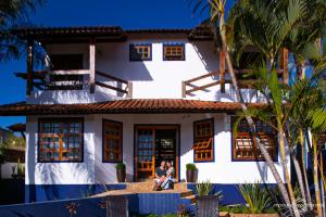 a couple sitting in front of a house at Pousada Caminho das Aguas in Brotas