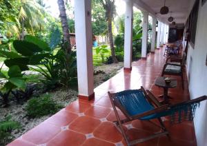 a porch of a house with chairs and plants at Posada Casa Madrid in Bacalar