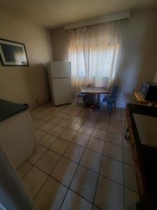 a small kitchen with a table and a refrigerator at Desert Hills Motel in Las Vegas