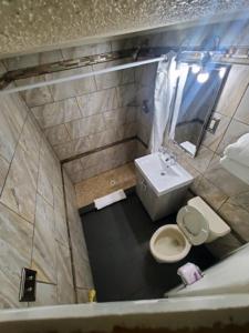 Baño pequeño con aseo y lavamanos en Desert Hills Motel, en Las Vegas