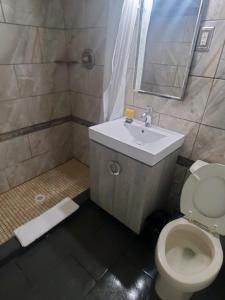 a bathroom with a toilet and a sink and a mirror at Desert Hills Motel in Las Vegas