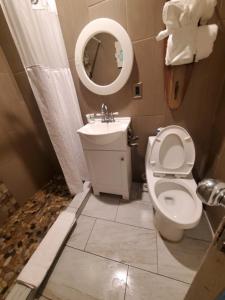 a bathroom with a toilet and a sink and a mirror at Desert Hills Motel in Las Vegas