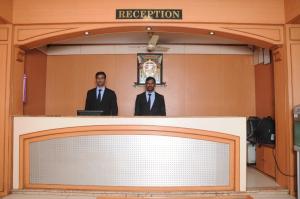 Dos hombres de traje están parados detrás de un mostrador. en Srinidhi Residency Murugeshpalya en Bangalore