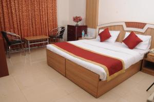 1 dormitorio con 1 cama, mesa y sillas en Srinidhi Residency Murugeshpalya en Bangalore