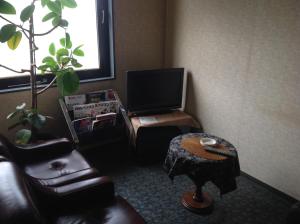 a living room with a couch and a tv at Asano Hotel in Kitakyushu