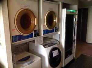 two washing machines and a washer and dryer in a room at Asano Hotel in Kitakyushu