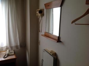 a bathroom with a window and a small refrigerator at Asano Hotel in Kitakyushu