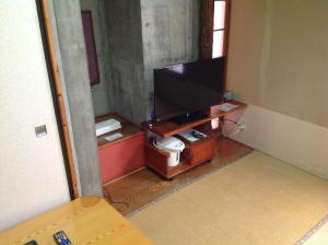 a living room with a tv in a room at Asano Hotel in Kitakyushu