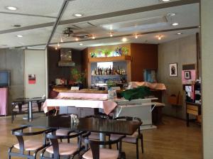 a restaurant with tables and chairs and a bar at Asano Hotel in Kitakyushu