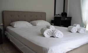 Una cama con toallas blancas encima. en Daniel and Marina en Galini