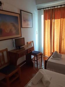 a room with a desk with a computer and a bed at Atlantis in Ermoupoli