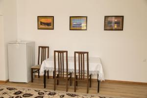 uma mesa de jantar com 4 cadeiras e um frigorífico em Mirage Hotel em Qyzylorda