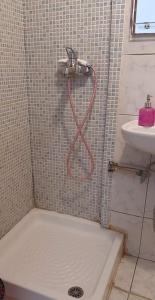 um chuveiro com uma mangueira vermelha na casa de banho em Atlantis em Hermópolis