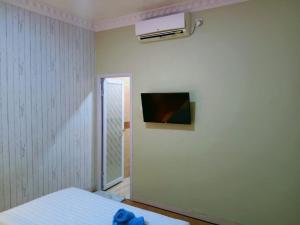 バタム・センターにあるSleepRest @ Golden Primaのベッドルーム1室(ベッド1台、壁掛けテレビ付)