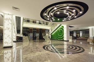 a lobby with a large chandelier in a building at Kaila Beach Hotel - All Inclusive in Alanya