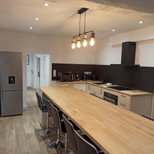 a large kitchen with a large wooden counter top at A 4 min du Zoo de Beauval La Maison à Partager Ch3 1er étage in Saint-Aignan