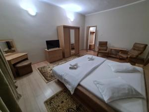 1 dormitorio con 1 cama blanca y sala de estar en Mi Sian Mura, en Lugoj