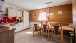 una cocina con mesa de madera y sillas. en Ferienhaus Stubai en Neustift im Stubaital