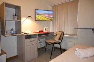 Pokój z biurkiem i telewizorem na ścianie w obiekcie Tallinn Apartments K8 Free parking w Tallinnie