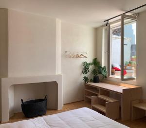 een slaapkamer met een bed, een bureau en een raam bij Violet Suites in Gent