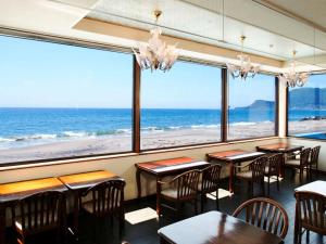 un restaurante con mesas y sillas y vistas al océano en Seaside Hotel Kamome, en Hakodate