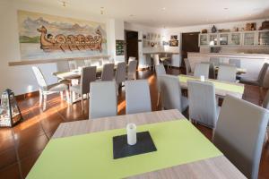 a dining room with tables and white chairs at Ferienwohnung Römerweinhof in Neumagen-Dhron