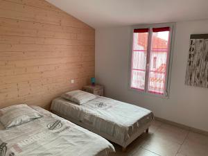 a bedroom with two beds and a window at La Fleur de Sel in La Flotte