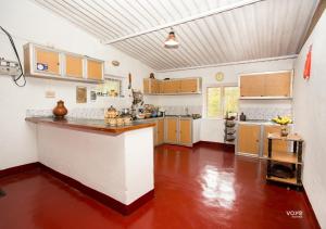 - une grande cuisine avec un grand comptoir dans une pièce dans l'établissement Moonlight Munnar Forest Bungalow with Private Waterfalls by VOYE HOMES, à Kanthalloor